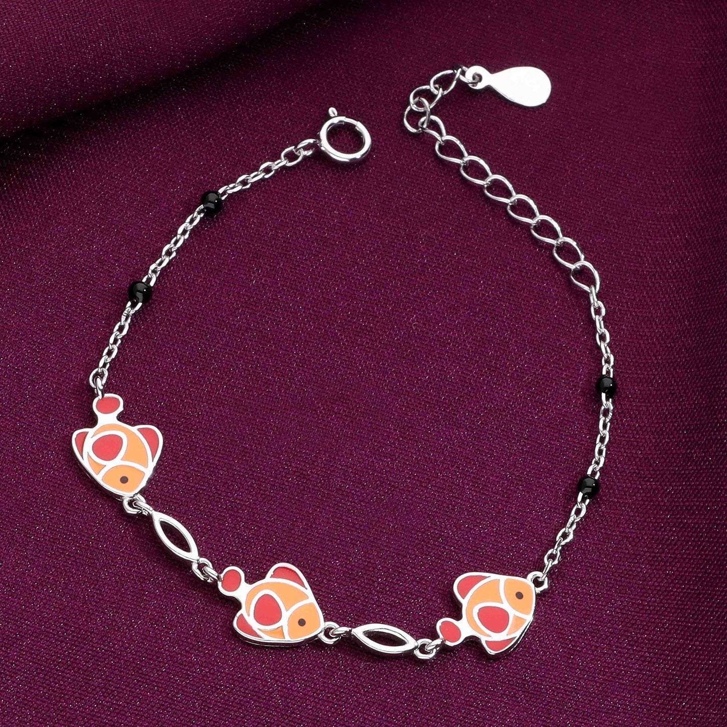 Silver chain bracelet with three orange clownfish charms and black bead