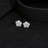 Close-up image of floral diamond stud earrings in 925 silver