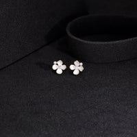 Gold-plated floral stud earrings with white enamel petals, pearl accent,