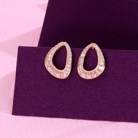 Rose gold teardrop stud earrings with round and baguette cubic zirconia stones