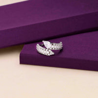 : Elegant silver ring with a pear-shaped center stone and sparkling crystals